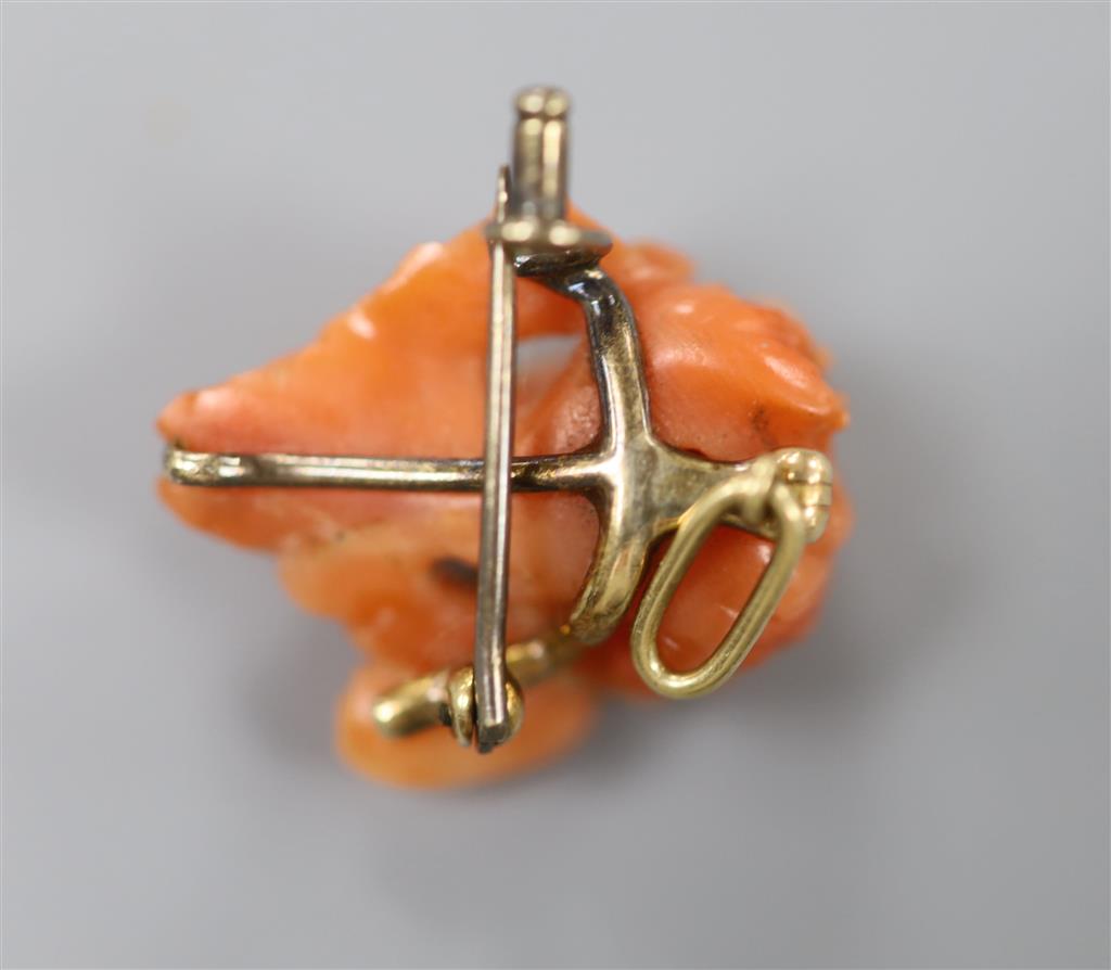 A 19th century yellow metal mounted coral brooch, carved as the bust of a cherub, 22mm, gross 5.3 grams.